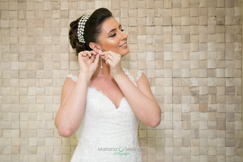 noiva colocando o brinco durante o making of em fotografia de Mariana Seelinger fotógrafa de casamentos e famílias em Niterói RJ