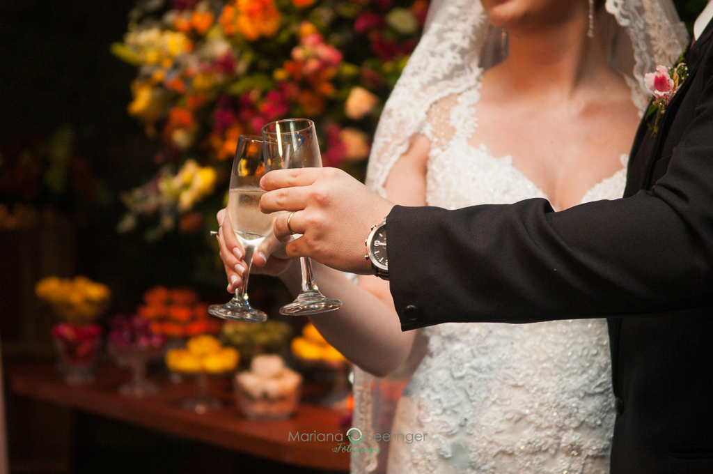 Foto detalhada dos noivos brindando na festa do casamento em fotografia de Mariana Seelinger Fotógrafa de Casamentos em Niterói e RJ