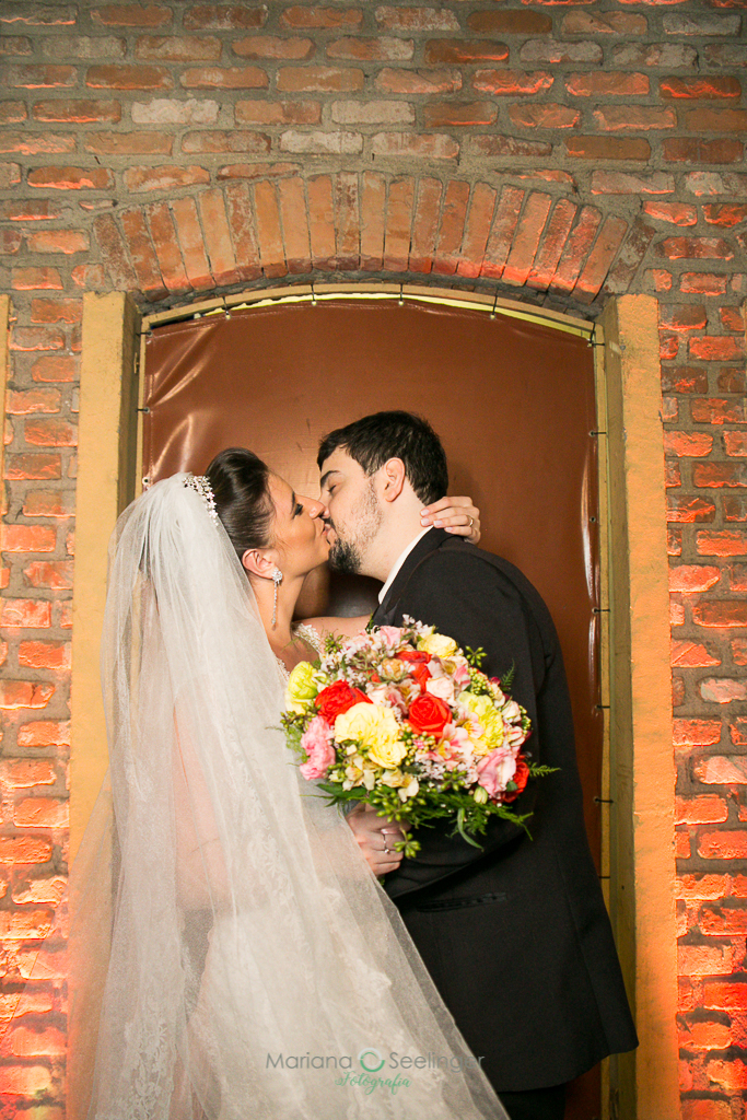 foto da noiva com o bouquet na mão beijando o noivo em fotografia de Mariana Seelinger Fotógrafa de Casamentos em Niterói e RJ