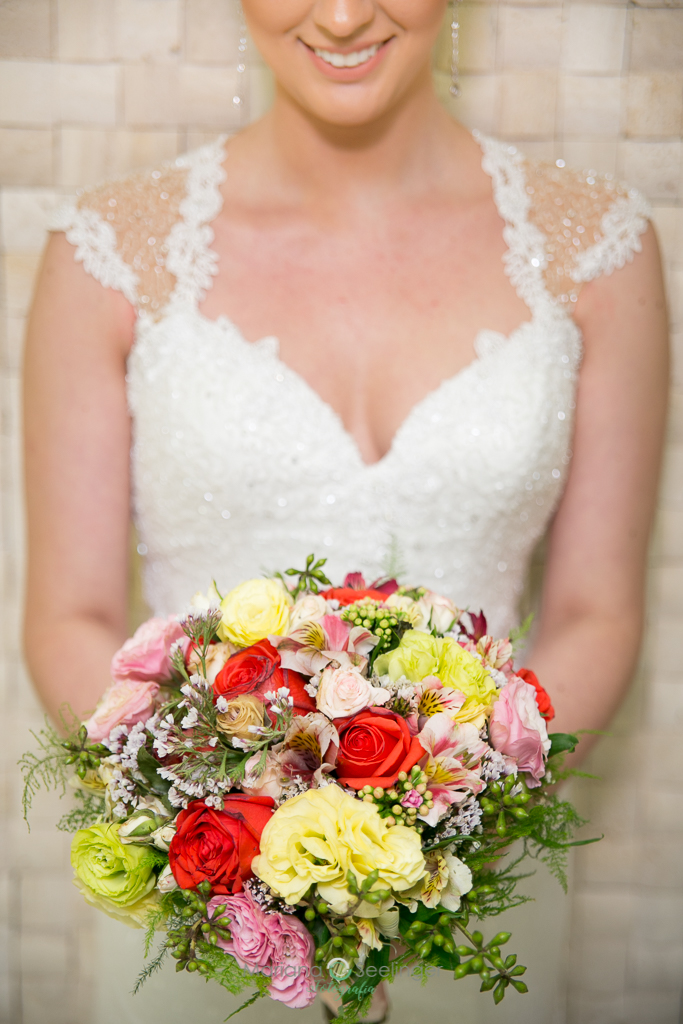 foto do sorriso da noiva e destaque ao bouquet de flores coloridas em fotografia de Mariana Seelinger fotógrafa de casamentos e famílias em Niterói RJ