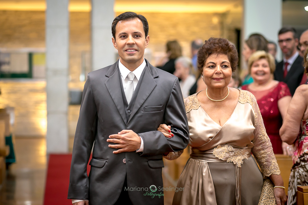 Noivo entrando na cerimonia do cassamento acompanhado da mãe em fotografia de Mariana Seelinger Fotógrafa de Casamentos em Niterói e RJ
