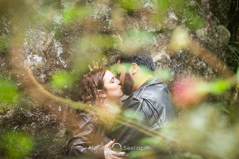 O casal se beija apoiado em uma pedra em Teresópolis - RJ por Mariana Seelinger Fotografia