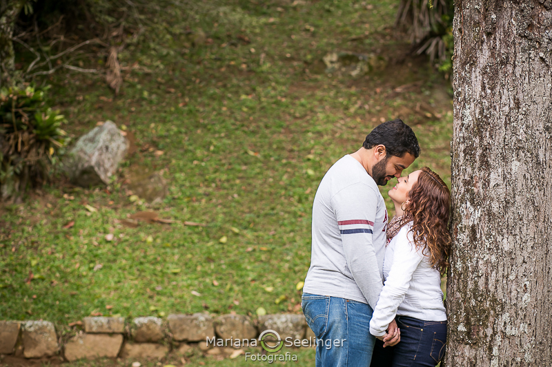 O casal de mãos dadas e se olhando profundamente em jardim em Teresópolis - RJ por Mariana Seelinger Fotografia