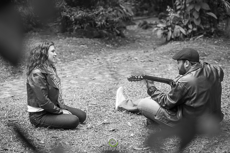 Detalhe em preto e branco do noivo tocando e a noiva assistindo