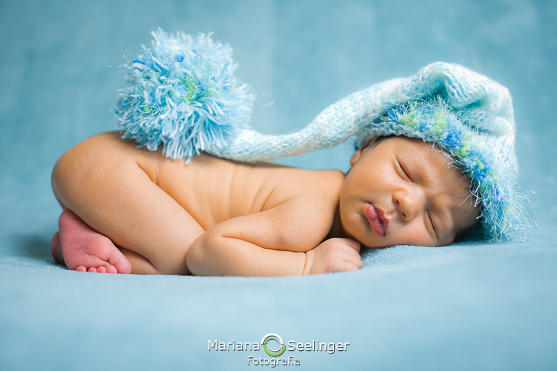 Touquinha azul e verde de tricô no newborn Gael