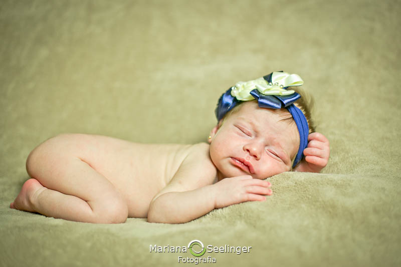 Maria Antonia de tiara azul deitada em ensaio recém nascido em Niterói - RJ