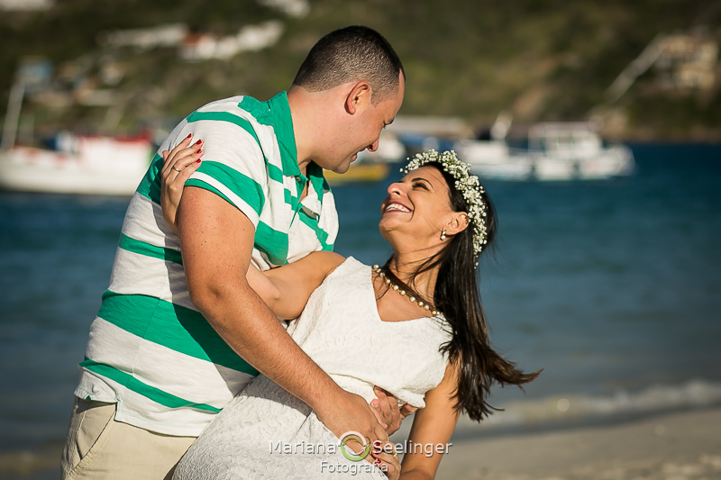 Close de Felipe inclinando Mariana em meio a praia de Arraial do Cabo RJ