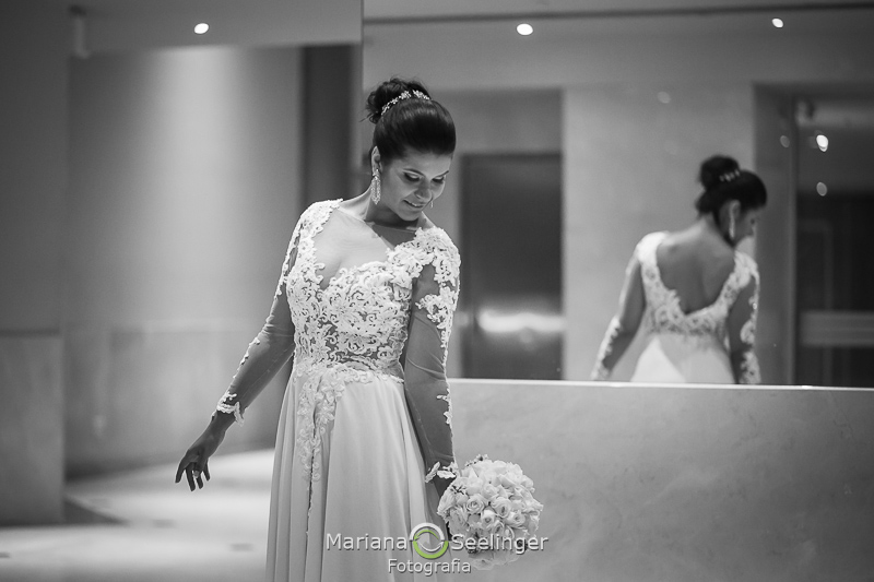 a noiva posa com o buquê na mão direita em fotografia preto e branco por Mariana Seelinger Fotografia