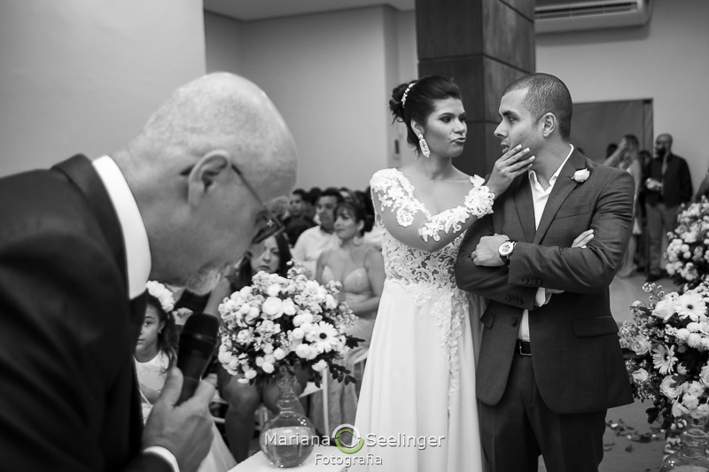 a noiva segura o rosto do noivo diante dos convidados em casamento no Rio de Janeiro - RJ