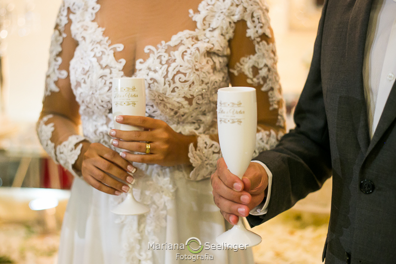 a noiva segura a sua taça e o noivo estende a dele em fotografia de casamento por Mariana Seelinger