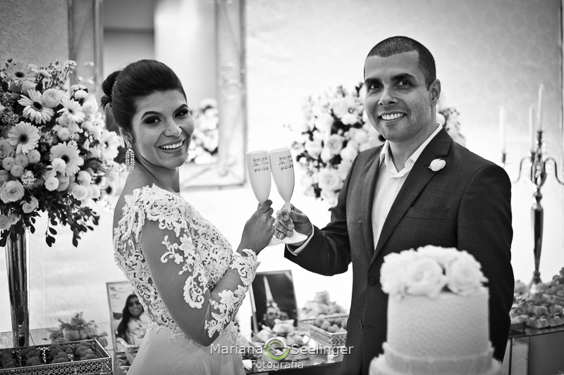 o brinde dos noivos em fotografia preto e branca por Mariana Seelinger