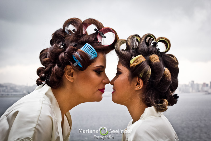 a noiva e sua filha de bobs nos cabelos encostando seus narizes em fotografia por Mariana Seelinger
