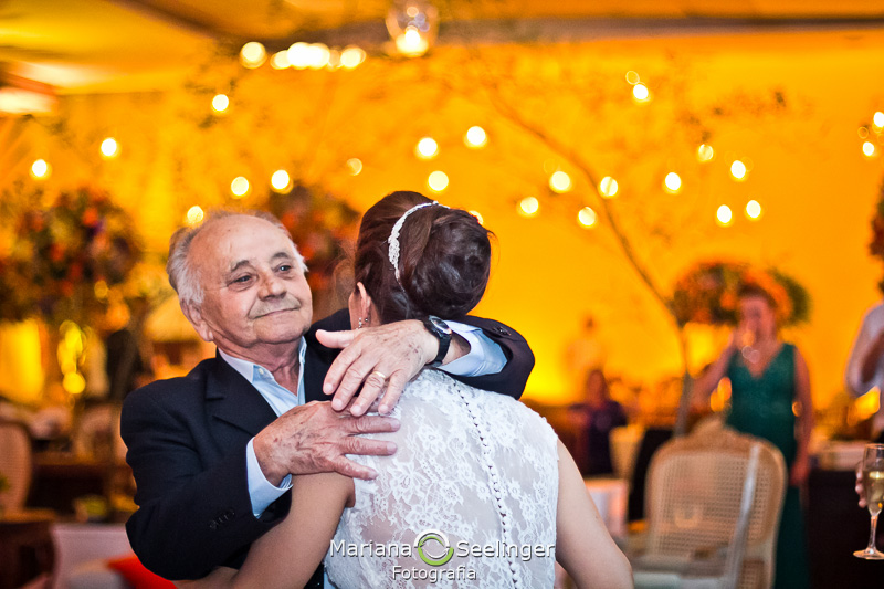 o abraço da noiva e seu sogro em fotografia por Mariana Seelinger em casamento na cidade de Niterói - RJ