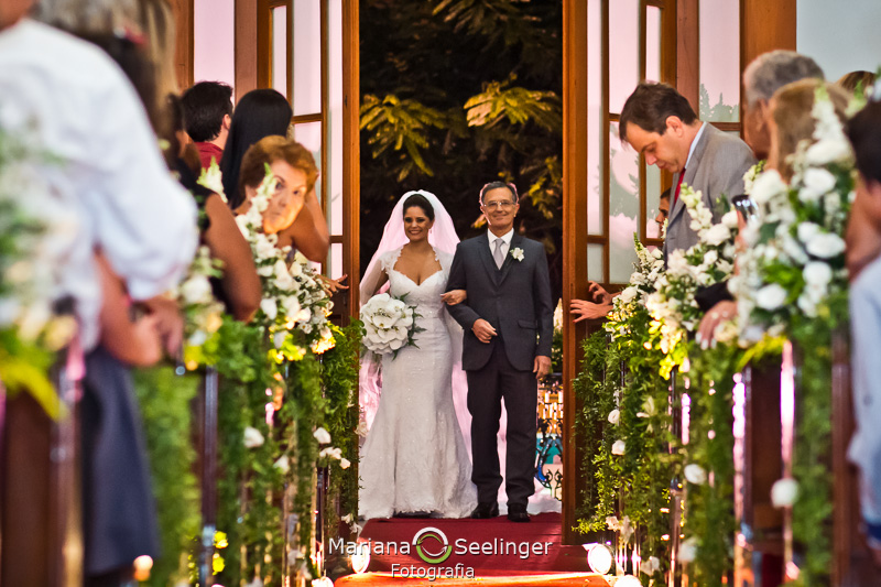 a noiva acompanhada do pai entra na Igreja em Fotografia por Mariana Seelinger