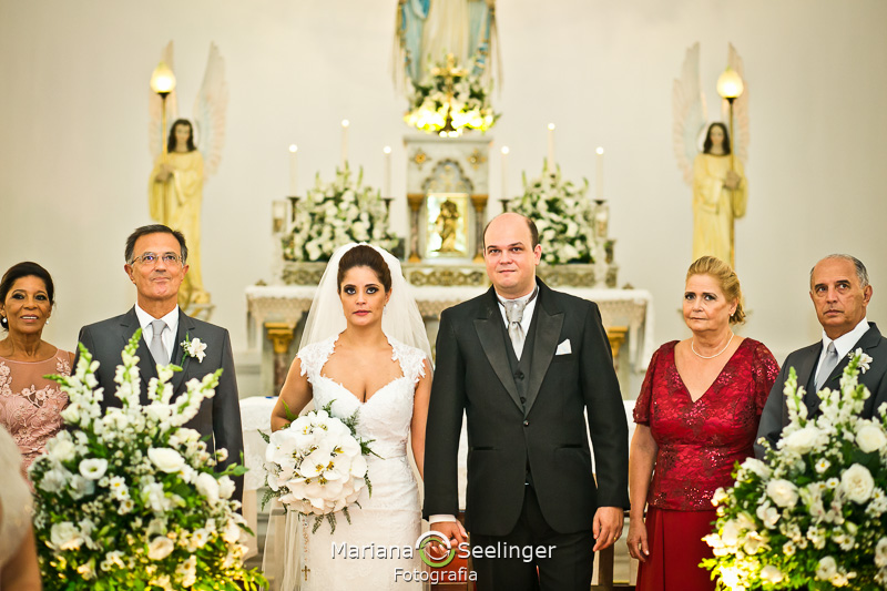 os noivos e seus pais e padrinhos no altar