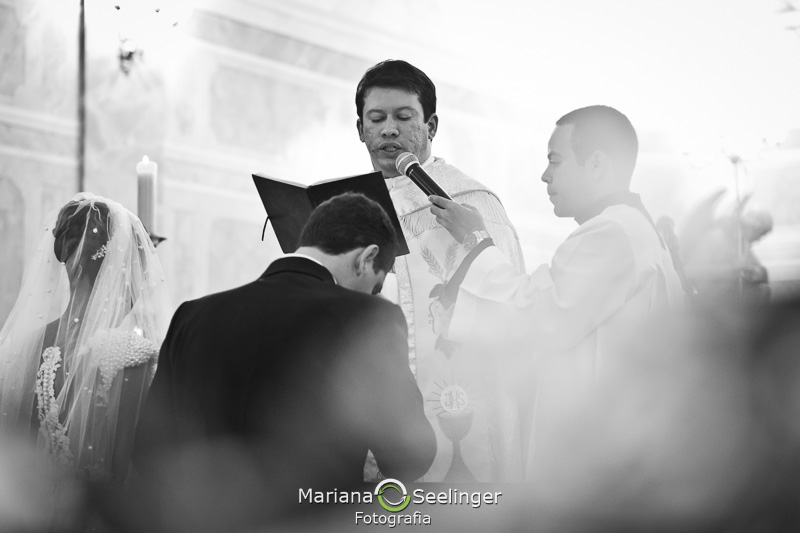 o padre dando a benção aos noivos em fotografia por Mariana Seelinger
