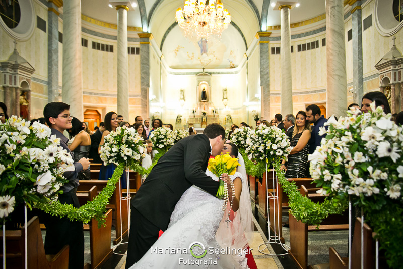 Tiago inclina Renata em um beijo diante da Igreja em Niterói - RJ em fotografia por Mariana Seelinger