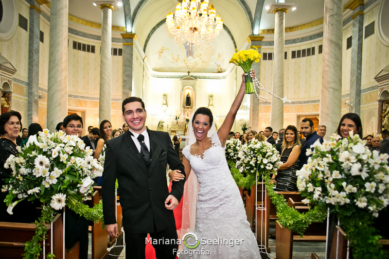 a noiva comemora com o buquê no alto sorridente em fotografia por Mariana Seelinger em Niterói - RJ