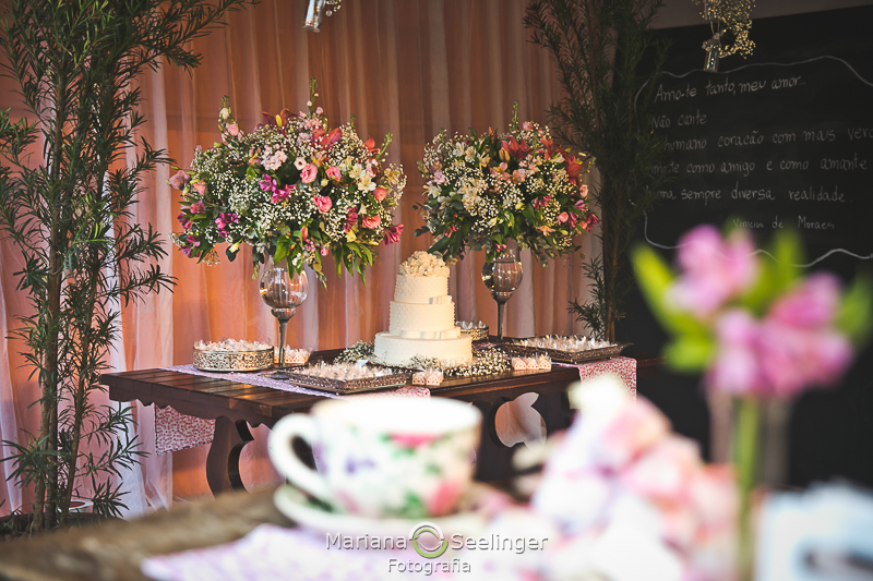 o bolo ao fundo com a xícara da decoração em fotografia de casamento por Mariana Seelinger