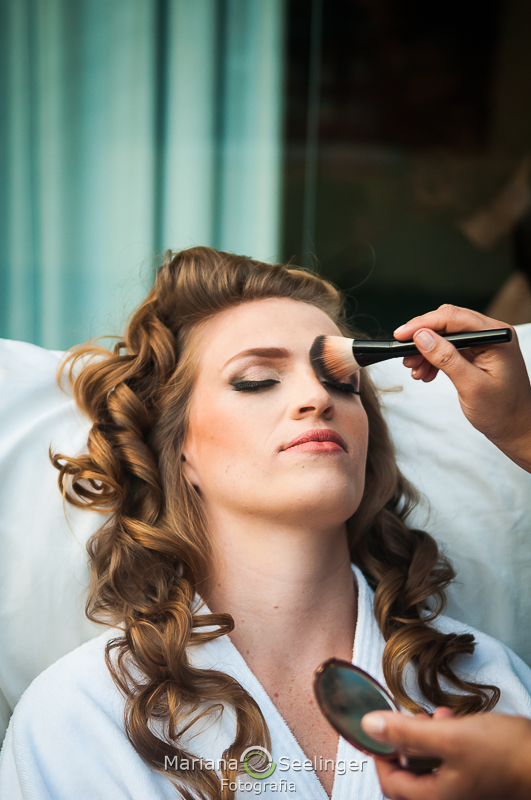 a noiva se maquiando em fotografia por Mariana Seelinger