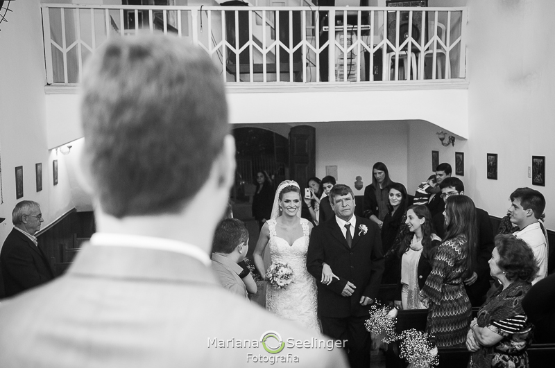 o noivo aguarda a entrada de sua noiva acompanhada pelo pai em fotografia de Mariana Seelinger