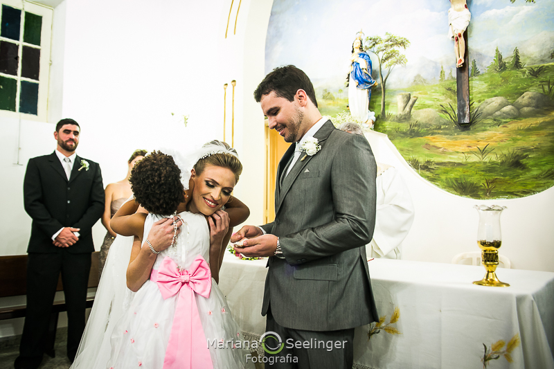 a noiva Thais abraça a daminha em seu casamento por Mariana Seelinger Fotografia