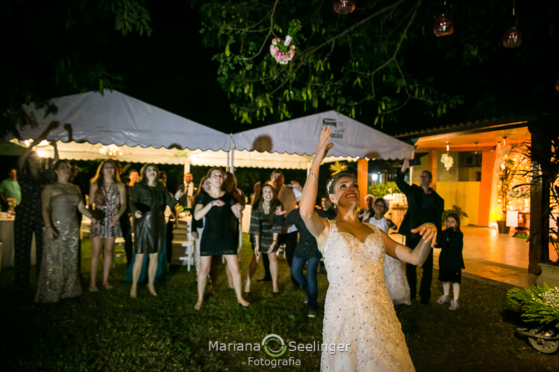 a noiva joga o buquê para as convidadas de seu casamento em Niterói - RJ em foto por Mariana Seelinger