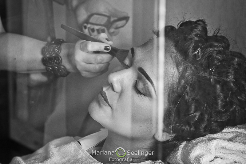 Foto da noiva durante o making of através do vidro em hotel em niteroi por Mariana Seelinger