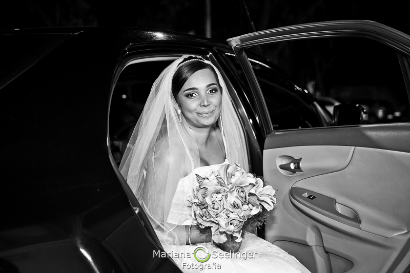 em preto e branco noiva sai do carro com o buquê