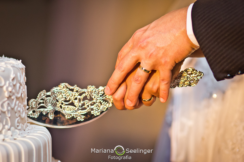 detalhe da aliança cortando o bolo