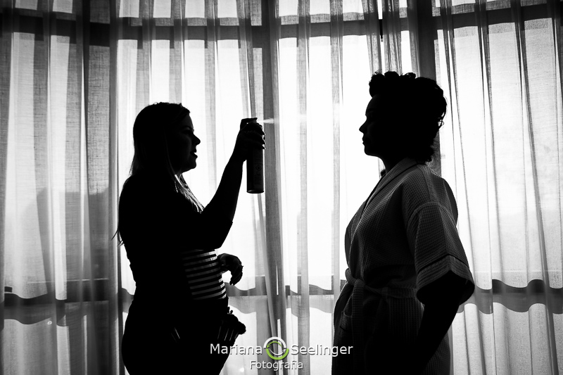 silhueta da noiva e da cabeleireira na fotografia de casamento Niterói por Mariana Seelinger recebendo o laquê