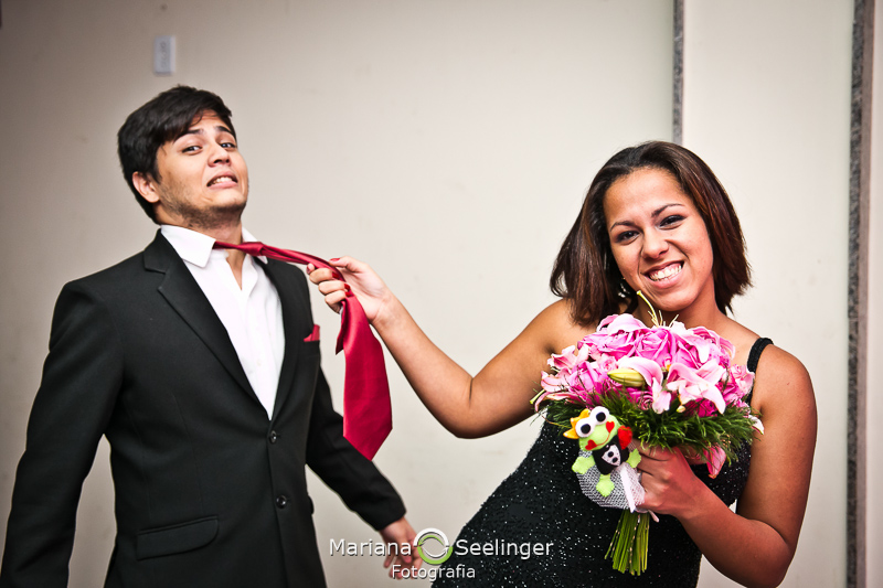 amiga da noiva feliz com o buquê segurando noivo pela gravata