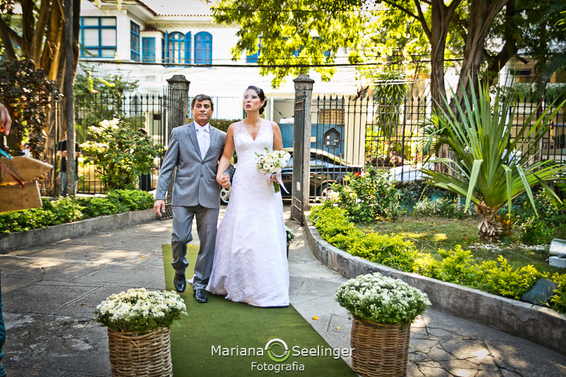 Noiva a caminho do altar acompanhada pelo pai em casamento registrado por Mariana Seelinger Fotografia de Casamentos e Familias em Niterói RJ