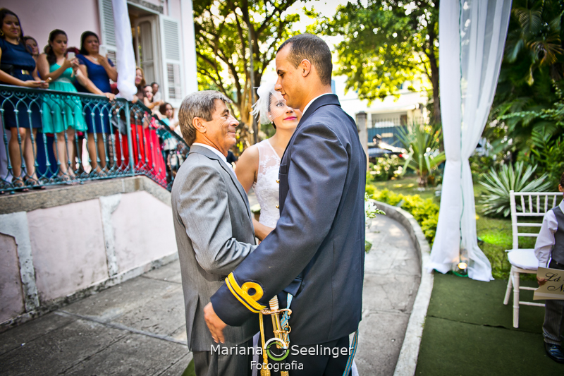 Noivo sendo cumprimentado pelo pai da noiva em casamento registrado por Mariana Seelinger Fotografia de Casamentos e Familias em Niterói RJ