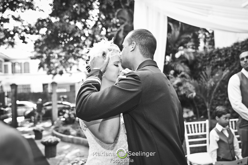 Foto em preto e branco do noivo dando um beijo na testa da noiva em casamento registrado por Mariana Seelinger Fotografia de Casamentos e Familias em Niterói RJ