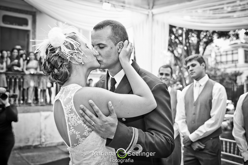 Foto em preto e branco dos noivos se beijando no altar da onde o casamento foi celebrado em fotografia de Mariana Seelinger Fotógrafa de Casamentos em Niterói e RJ