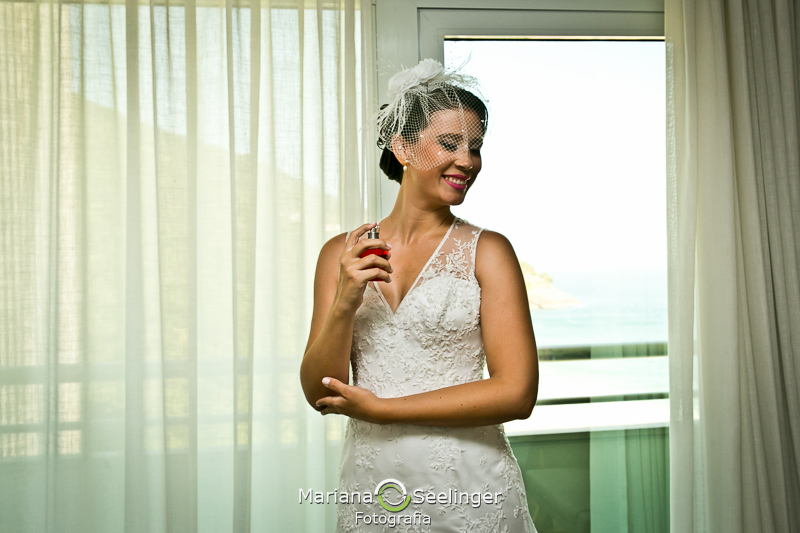 Noiva passando perfume durante making of em casamento registrado por Mariana Seelinger Fotografia de Casamentos e Familias em Niterói RJ