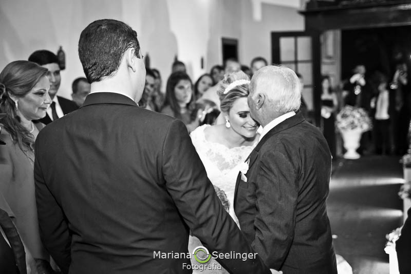 Foto em preto e branco do noivo recebendo a noiva em casamento registrado por Mariana Seelinger Fotografia de Casamentos e Familias em Niterói RJ