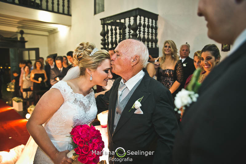 Pai da noiva dando um beijo na testa dela em casamento registrado por Mariana Seelinger Fotografia de Casamentos e Familias em Niterói RJ