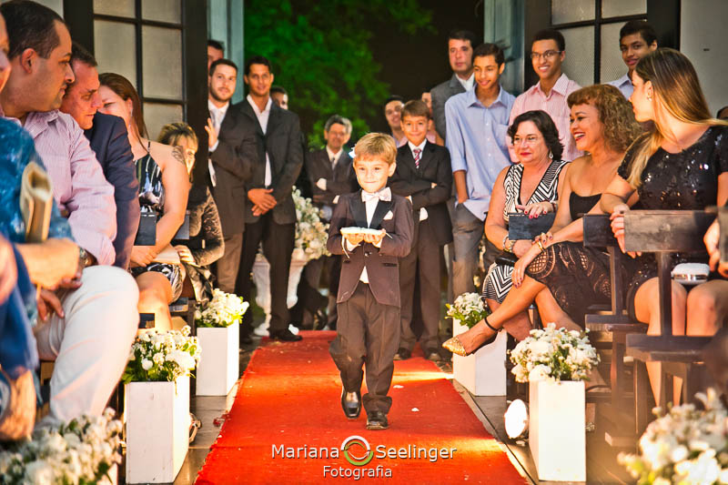 Pajem levando alianças para os noivos no altar em casamento registrado por Mariana Seelinger Fotografia de Casamentos e Familias em Niterói RJ