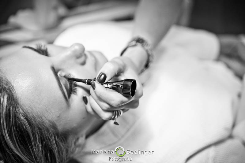 Noiva passando maquiagem em casamento registrado por Mariana Seelinger Fotografia de Casamentos e Familias em Niterói RJ