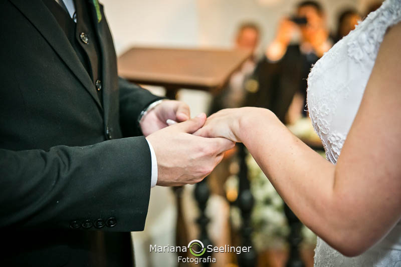 Foto  do noivo botando aliança na noiva em casamento registrado por Mariana Seelinger Fotografia de Casamentos e Familias em Niterói RJ