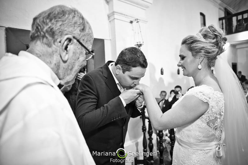 Noivo beijando mão da noiva em casamento registrado por Mariana Seelinger Fotografia de Casamentos e Familias em Niterói RJ