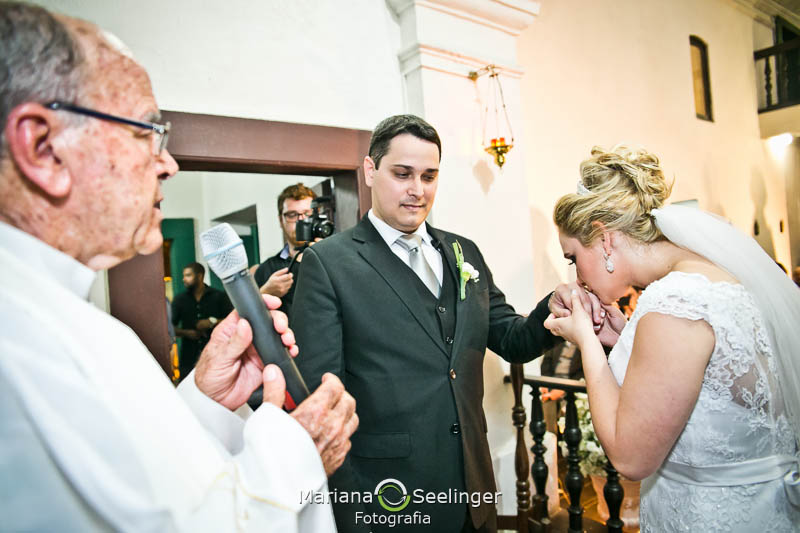 Noiva beijando a mão do noivo em casamento registrado por Mariana Seelinger Fotografia de Casamentos e Familias em Niterói RJ