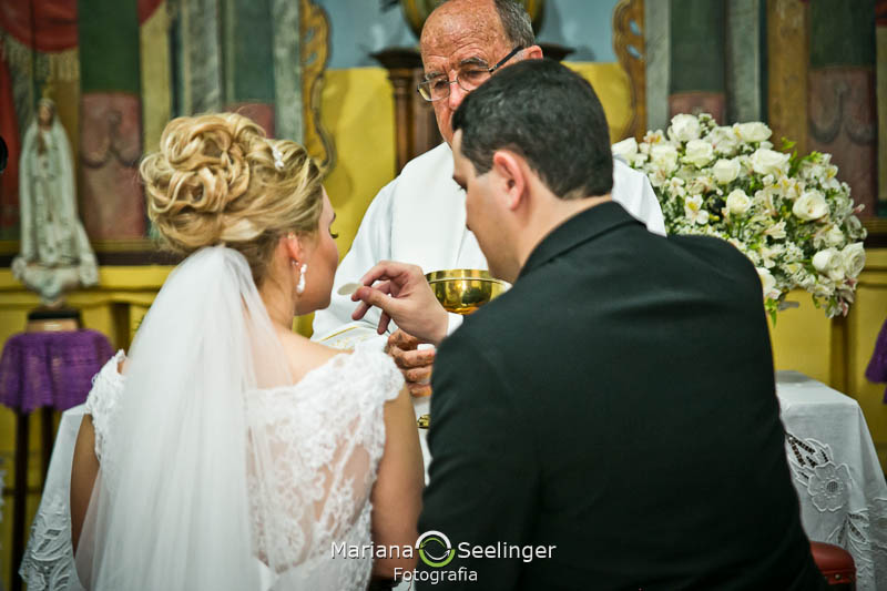 Noiva recebendo hóstia do noivo em casamento registrado por Mariana Seelinger Fotografia de Casamentos e Familias em Niterói RJ
