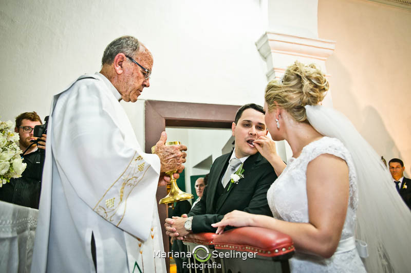 Noiva dando hóstia para noivo em casamento registrado por Mariana Seelinger Fotografia de Casamentos e Familias em Niterói RJ