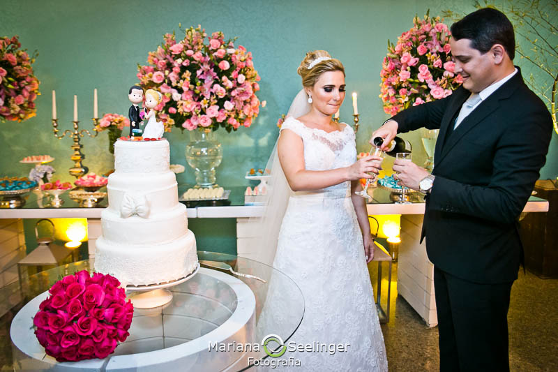 Noivos ao lado da mesa do bolo em casamento registrado por Mariana Seelinger Fotografia de Casamentos e Familias em Niterói RJ