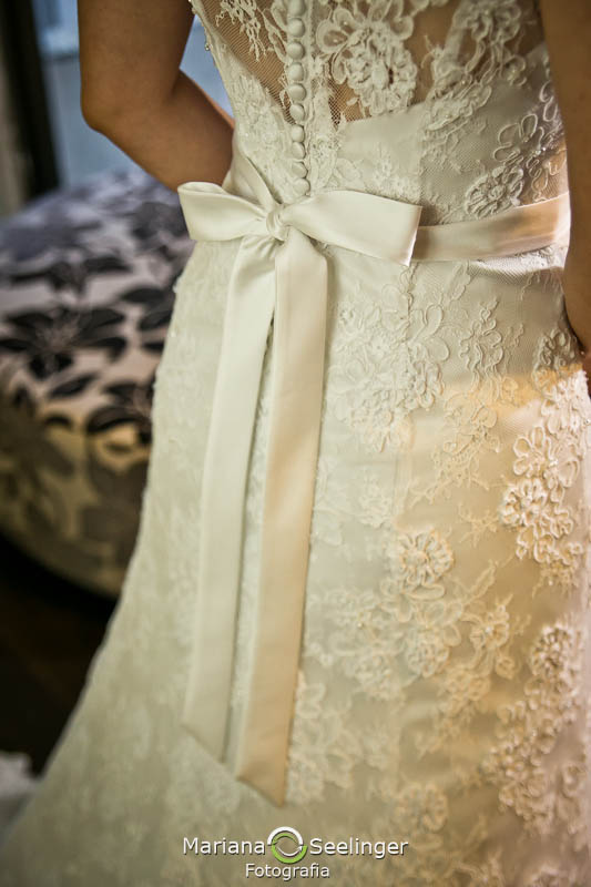 foto do laço do vestido da noiva no dia do casamento durante o making of realizado no hotel mercure orizzonte por mariana seelinger fotografia