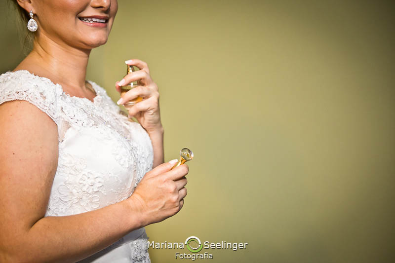 noiva passando perfume em making of em niterói em casamento registrado por Mariana Seelinger Fotografia de Casamentos e Familias em Niterói RJ