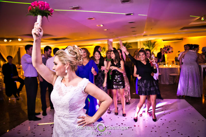 Noiva jogando o bouquet em casamento registrado por Mariana Seelinger Fotografia de Casamentos e Familias em Niterói RJ